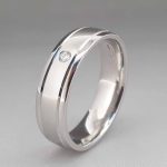 White gold band set with a single diamond.