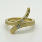 Cross over ring in 18ct gold. Diamond set